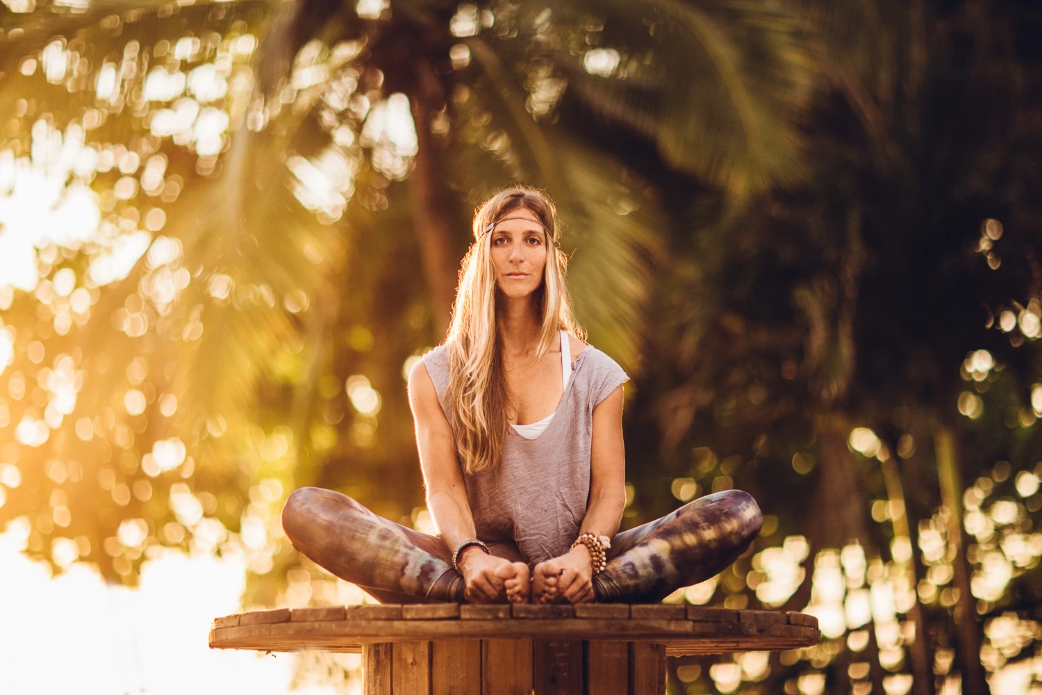 Lisa Lange beim Yoga auf einem Holzsockel im warmen Abendlicht